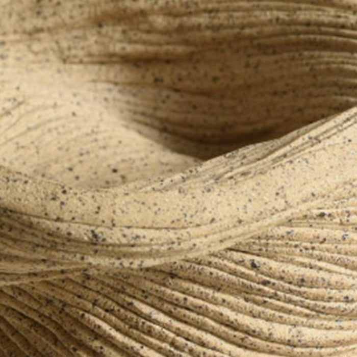 Close-up of the coiled tan porcelain small bowl highlighting the fine horizontal ridges and speckled surface