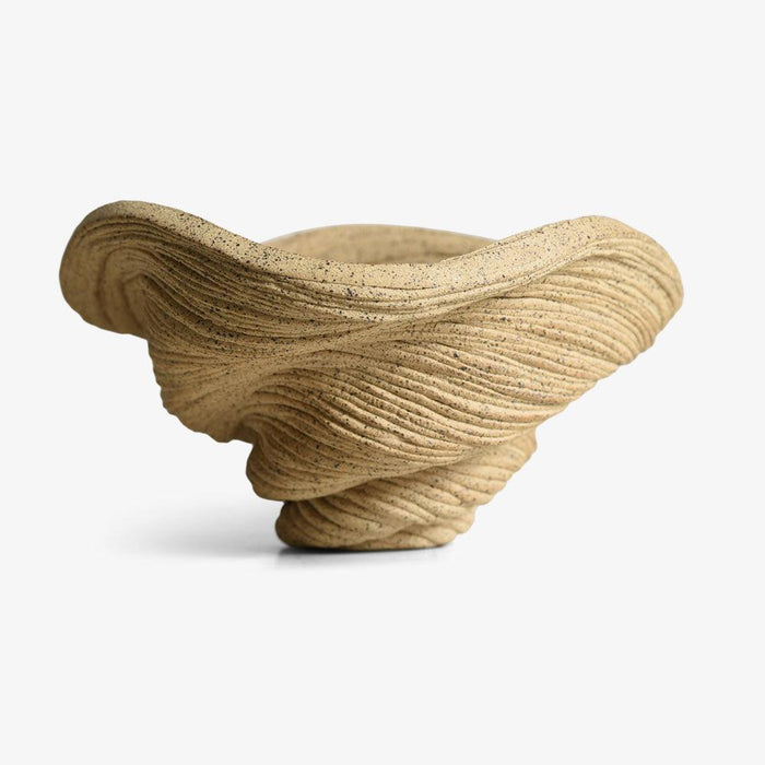 Small porcelain sculpture tan with visible texture shaped like a coiled bowl with a wide fluted opening