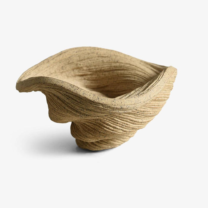 Small tan porcelain sculpture textured with fine lines shaped like a coiled bowl viewed from a slight angle