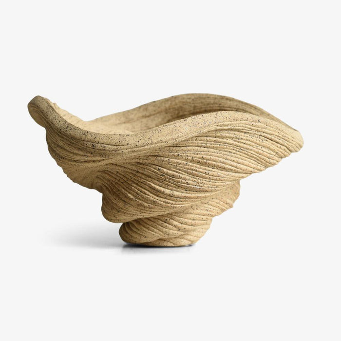 Tan porcelain sculpture a small coiled bowl with textured surface shown from a side angle