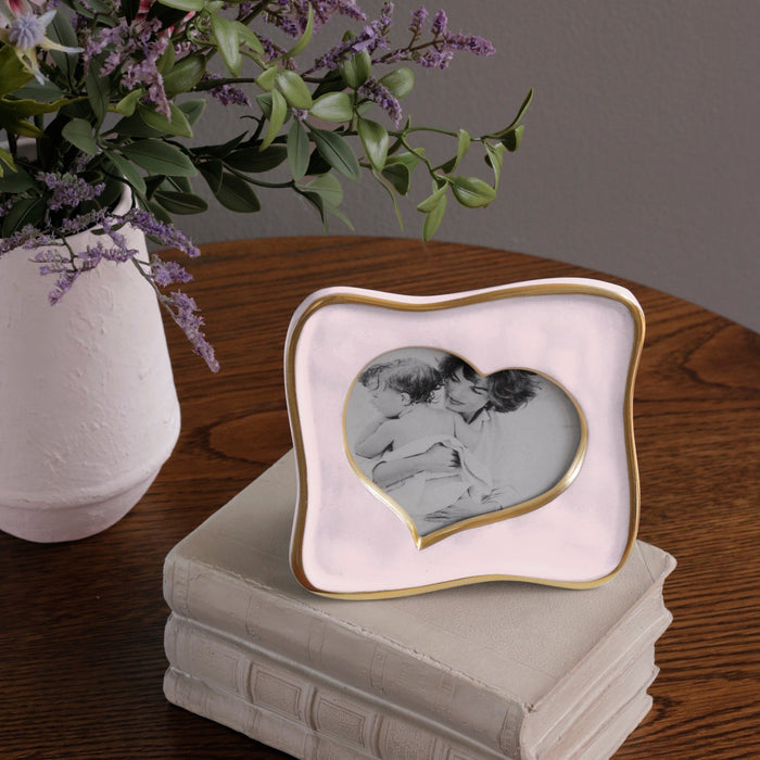 Beatriz Ball Frame Encanto Curved Heart 5 x 5 — On books beside a separate vase