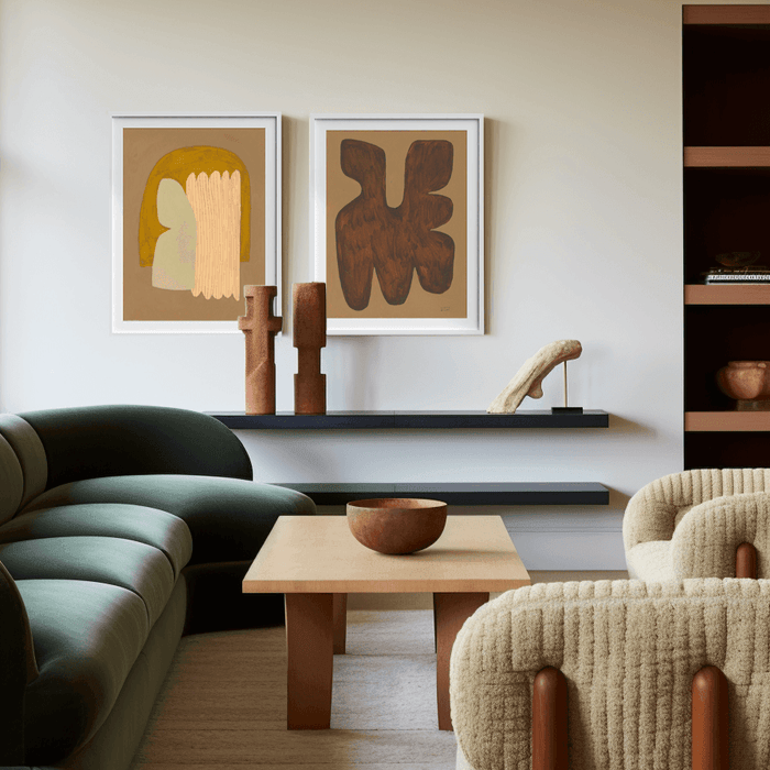 Abstract art and wood decor in a living room with a green sofa two white armchairs and a coffee table